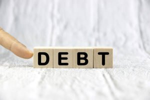 debt wording or text on wood block with hand. finance and business concept.